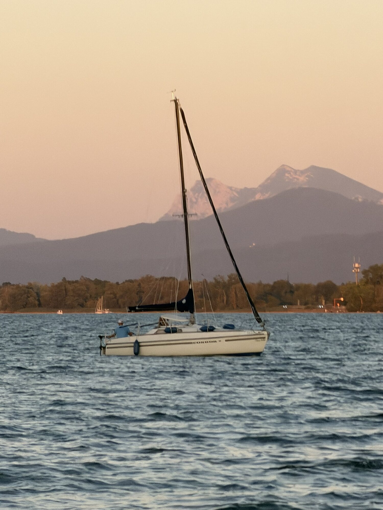 Segelboot Condor 7 auf dem Chiemsee im Abendlicht vor den Alpen