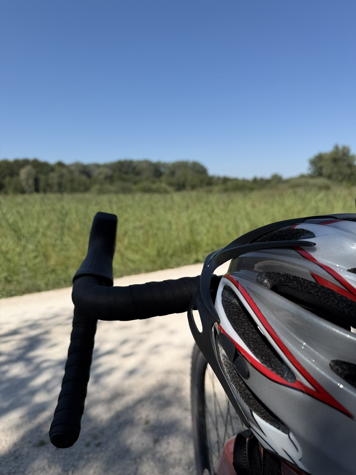 Lenker und Helm des Gravel-Bikes auf dem Radweg am Chiemsee