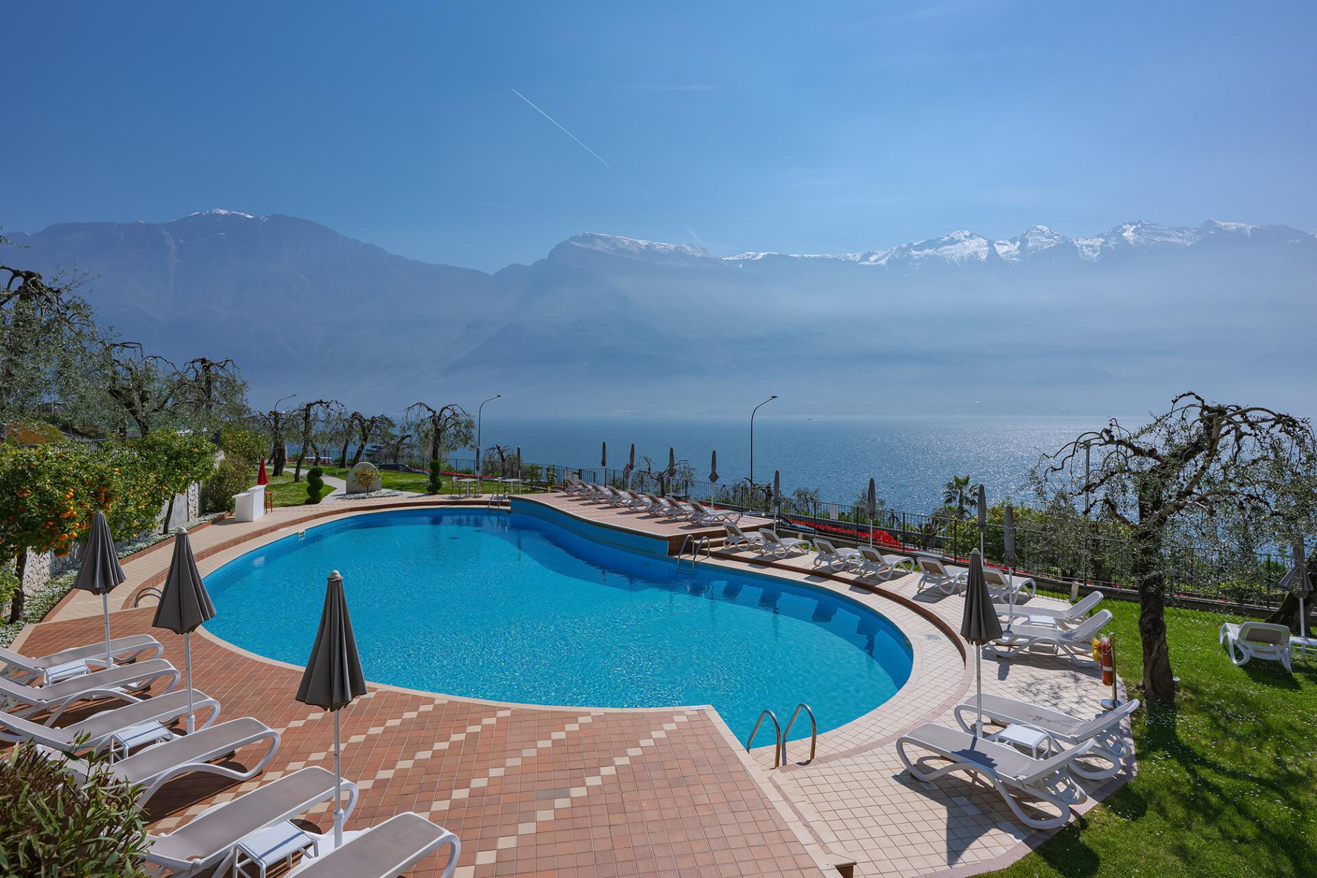 Poolanlage von oben, mit Blick auf den Gardasee und die schneebedeckten Berge