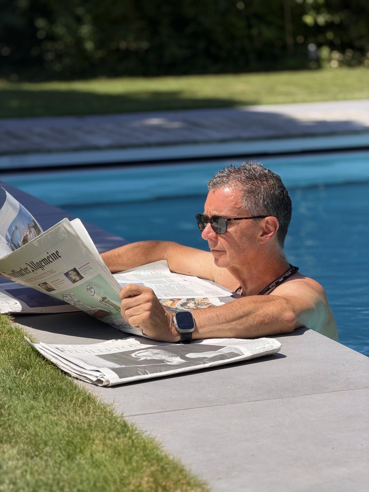 Andi mit der Zeitung am Pool