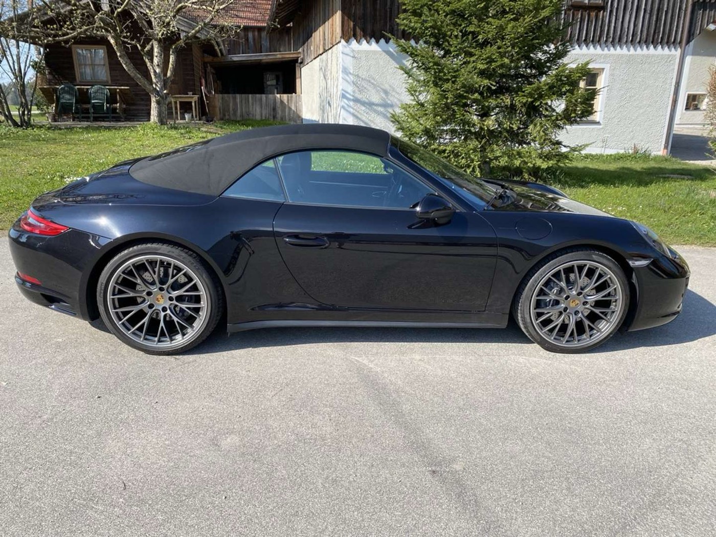Porsche 911 Carrera 4 Cabrio in der Seitenansicht vor grüner Wiese