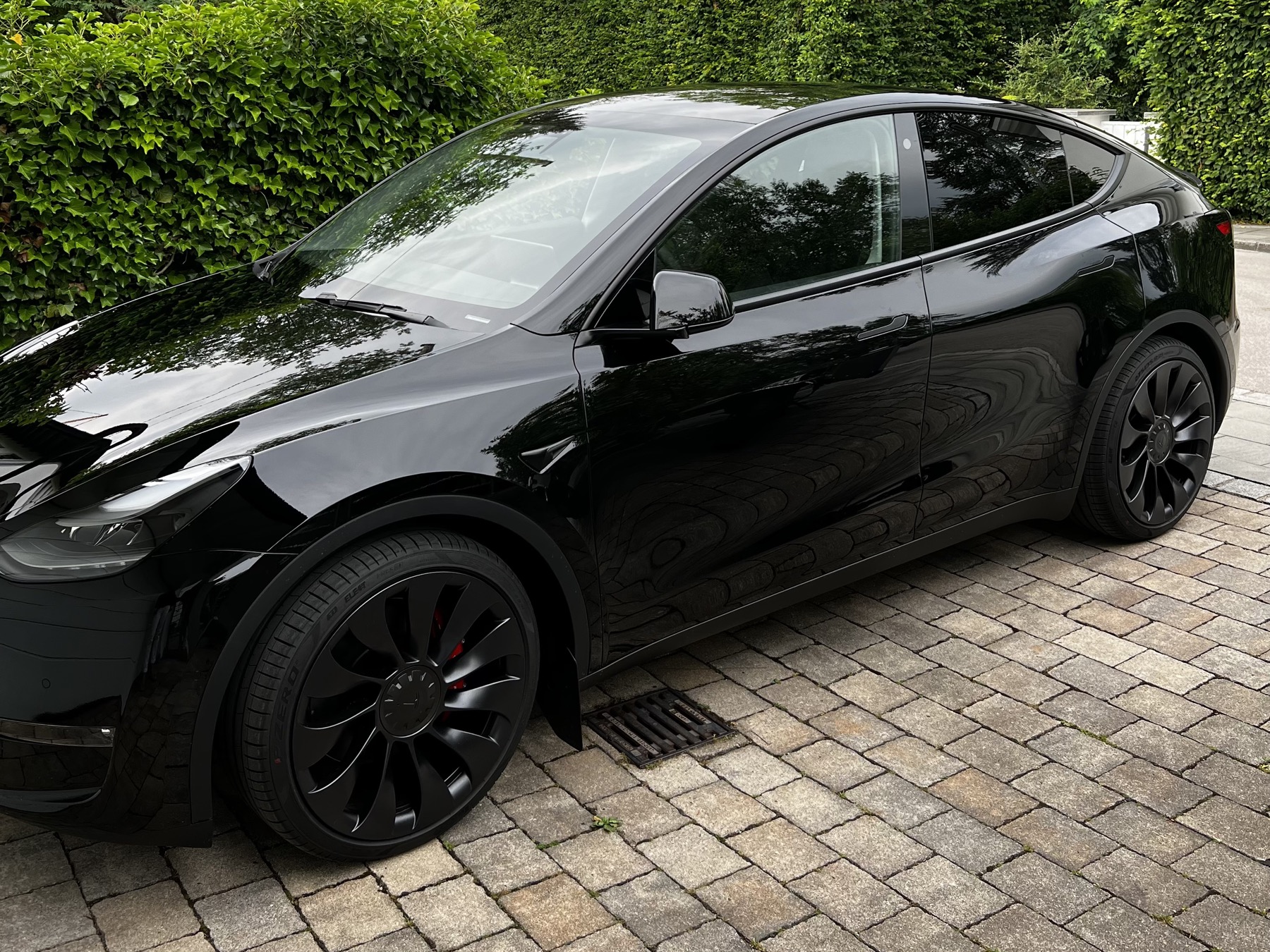 Schwarzer Tesla Model Y Performance in der Einfahrt